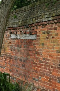 The softness of lime mortar has allowed the doorway in an old garden wall to  be filled with respect to the bond pattern.